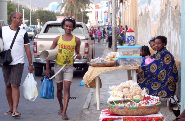 Still from the documentary: 2 people walking along a market street