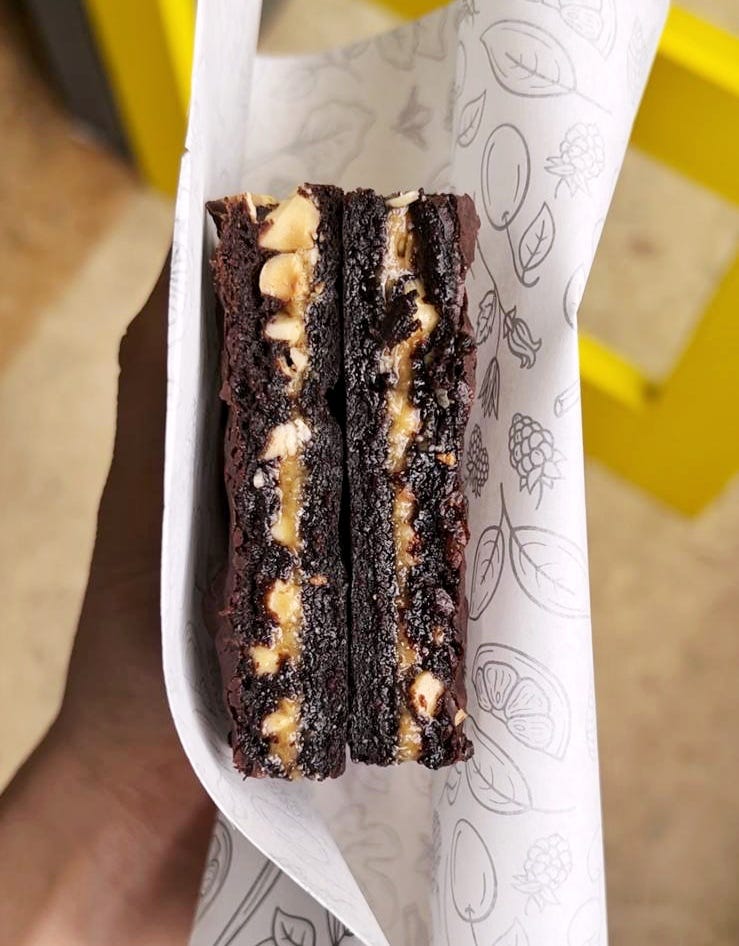 Brownie with hazelnut praline cross-section held in a hand.