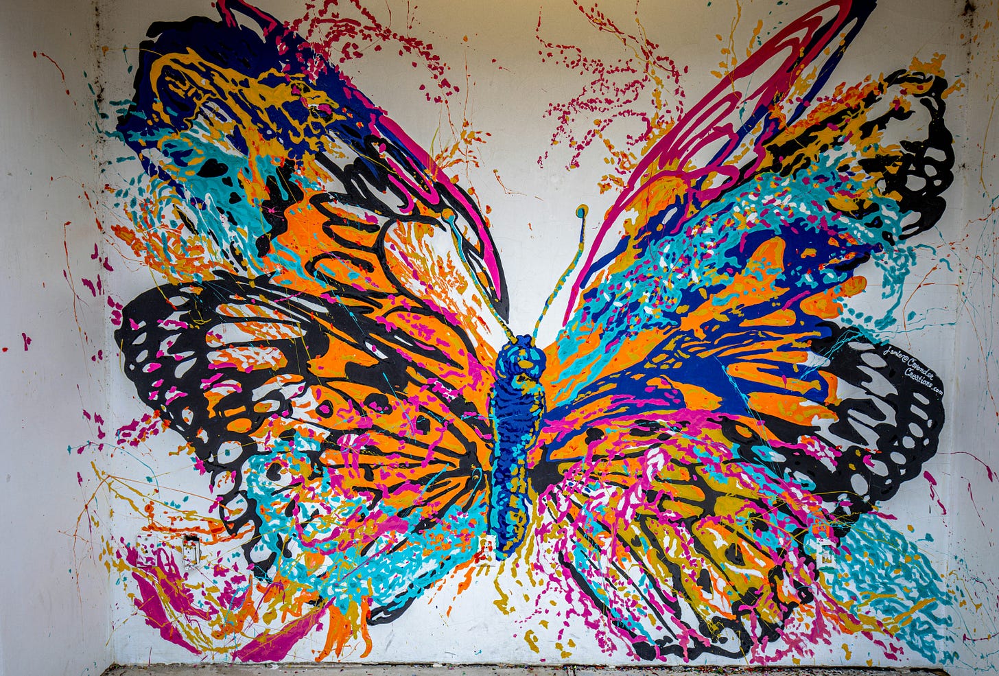 Multi-colored, paint-splattered butterfly mural