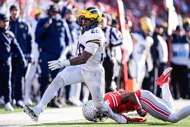 Michigan running back Kalel Mullings (20) runs against Ohio State safety Caleb Downs (2)during the second half at Ohio Stadium in Columbus, Ohio on Saturday, Nov. 30, 2024.