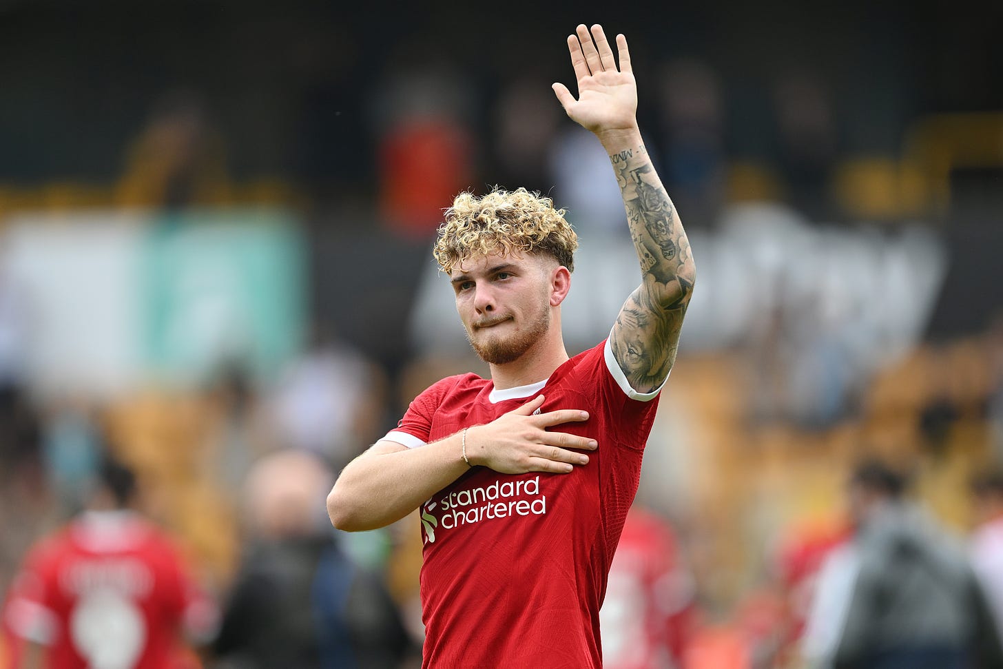 Liverpool midfielder Harvey Elliott raises his left arm to salute fans after the Reds' 3-1 win at Wolves