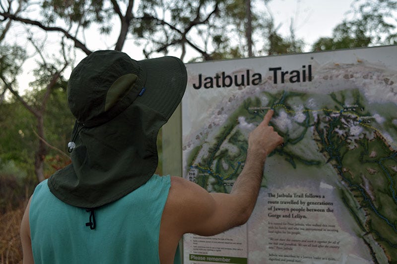 A man in a singlet and hat points to a map marked as The Jatbula Trail.