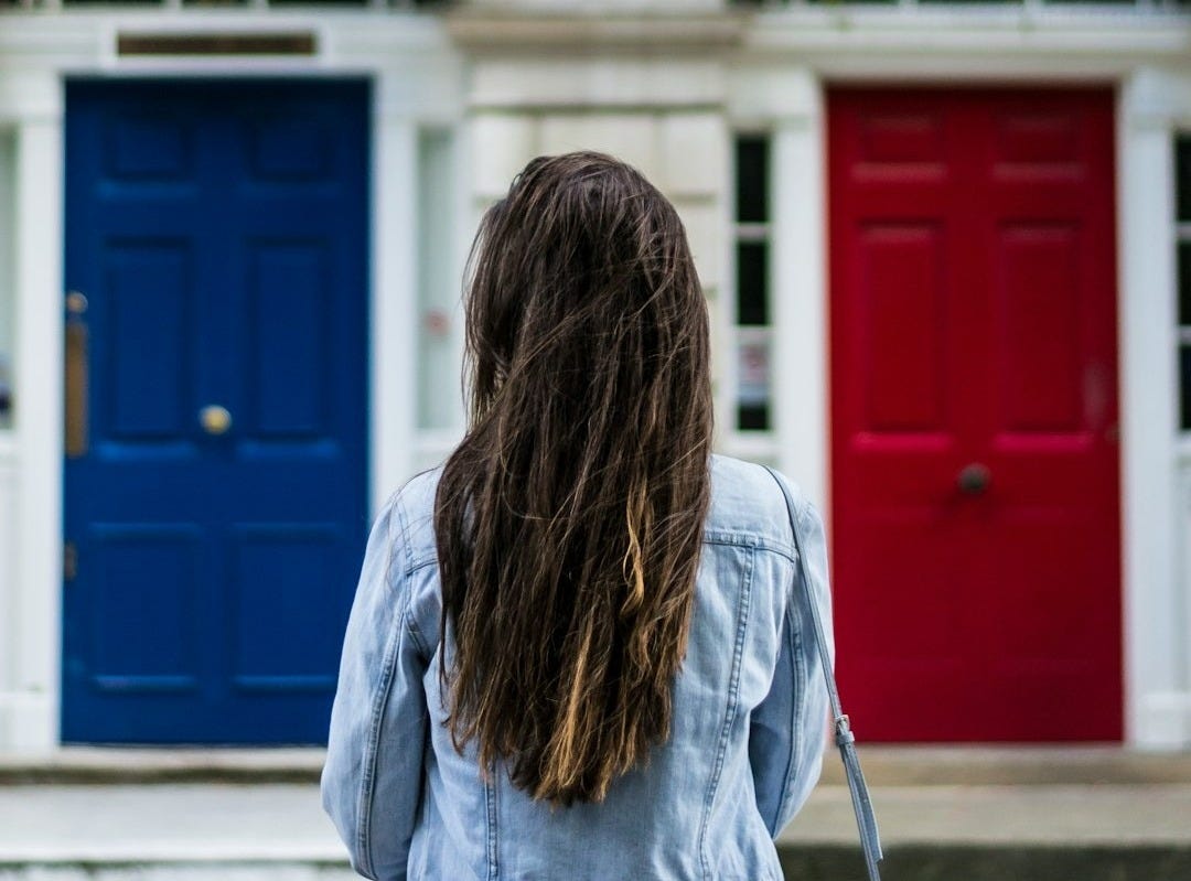 woman with jacket on front of concrete building