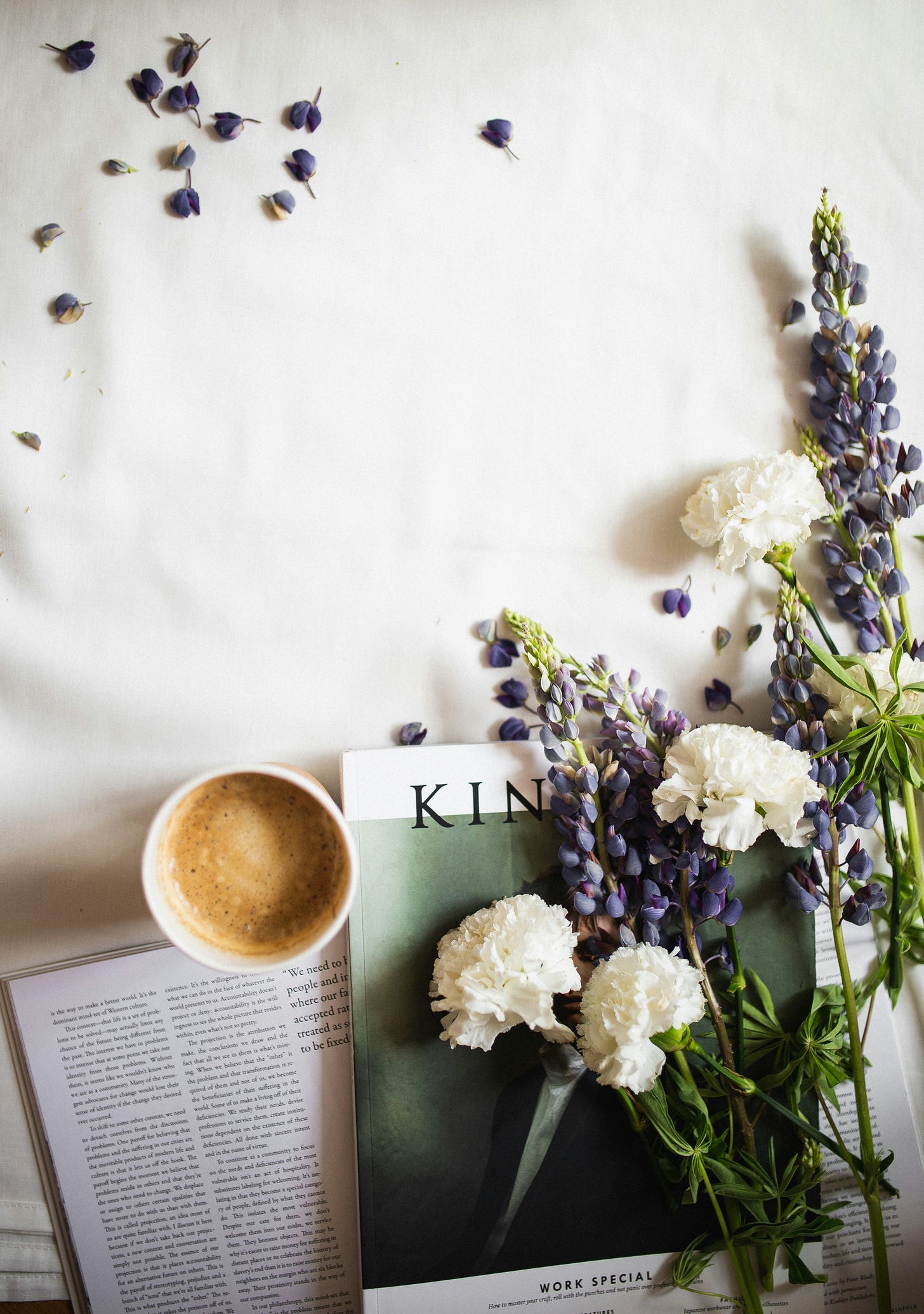 Photo of a coffee and fresh flowers next to a copy of Kinfolk Magazine.