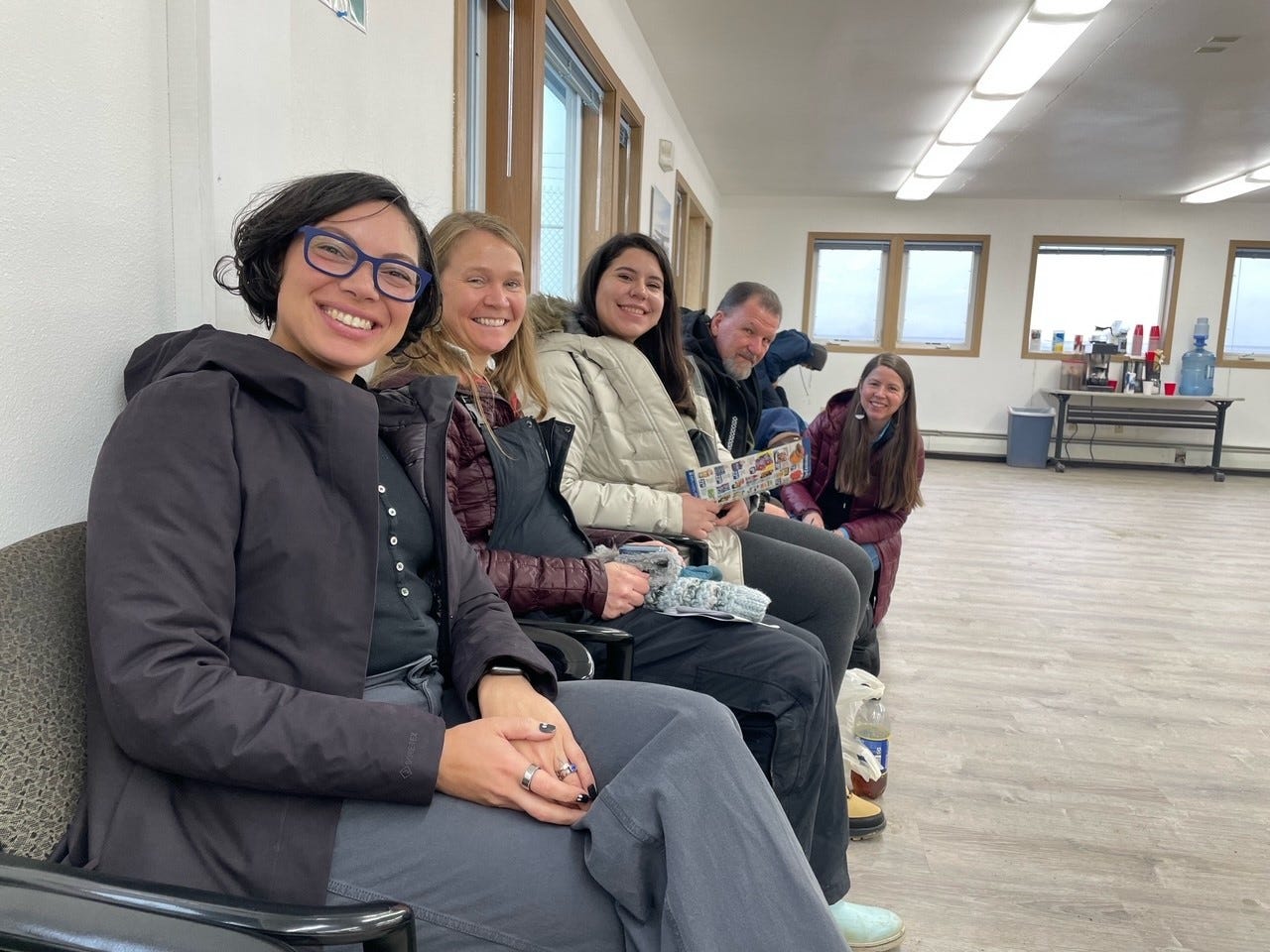 Image of Trust and Friends representatives waiting in a small airport waiting room