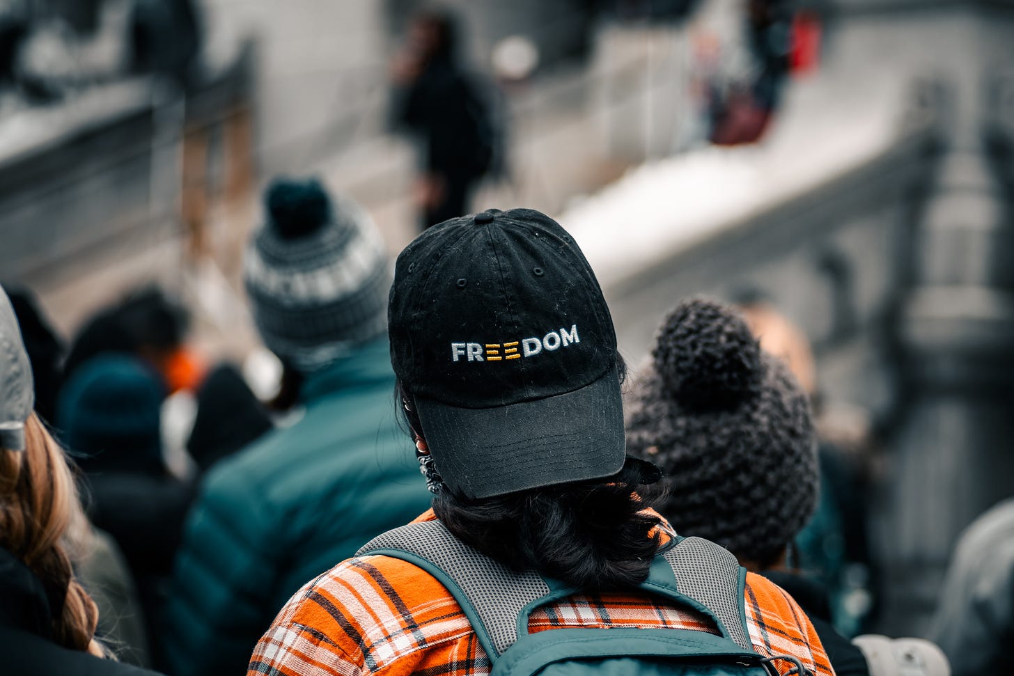 A photo of a person wearing a hat backwards, which says FREEDOM on it.