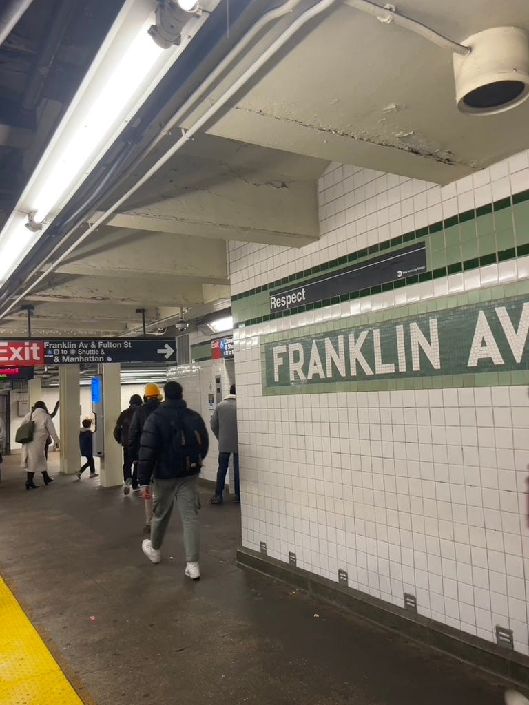 The Franklin Ave. C train subway stop. Franklin "Av" spelled out in green and white tiles on the wall.