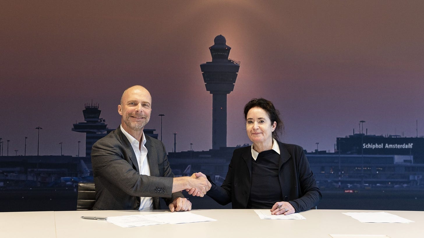 Robert Carsouw and Meiltje de Groot shaking hands, with plans on collaboration between Schiphol and Groningen Airport Eelde