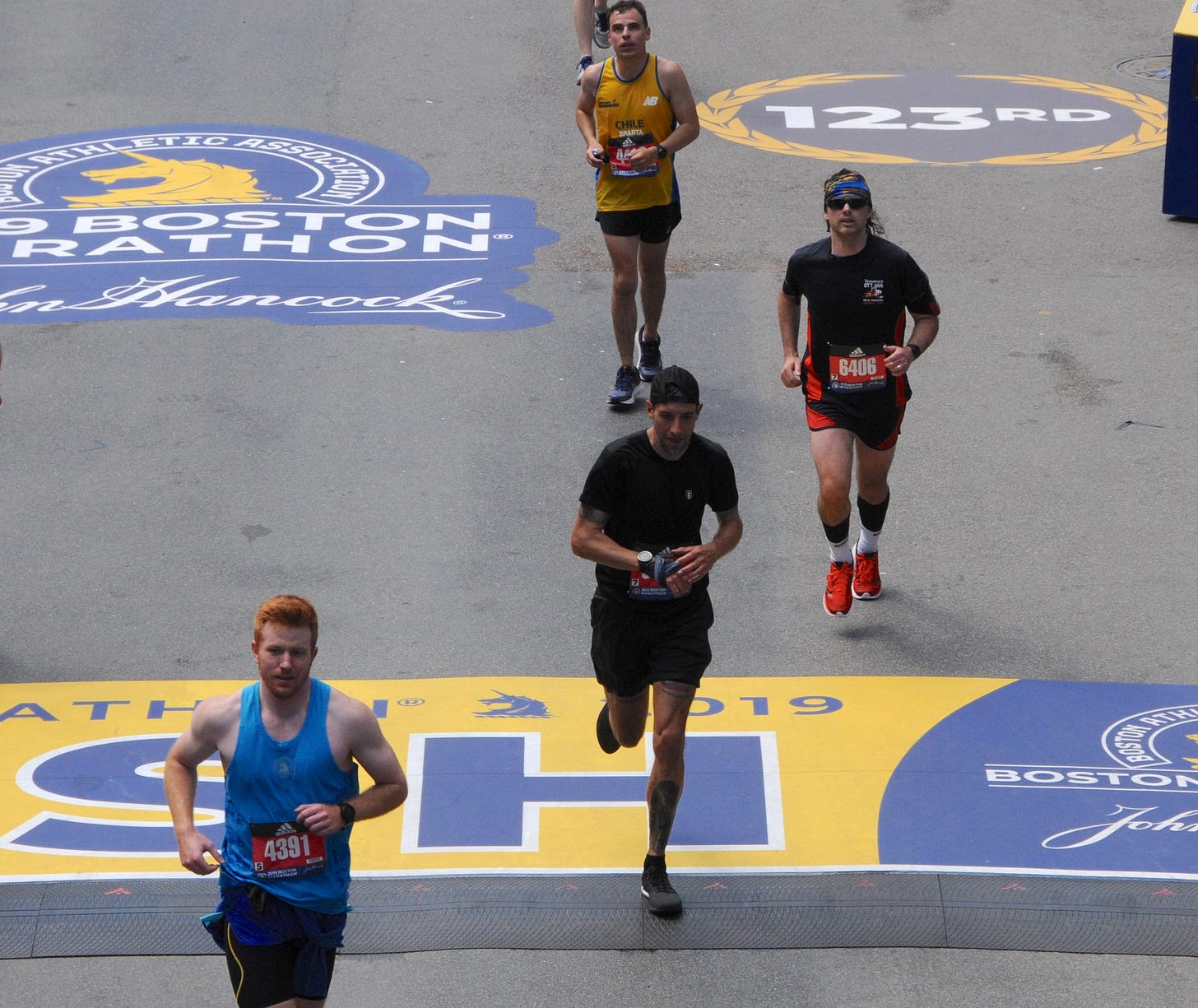The author crossing the finish line of the Boston Marathon