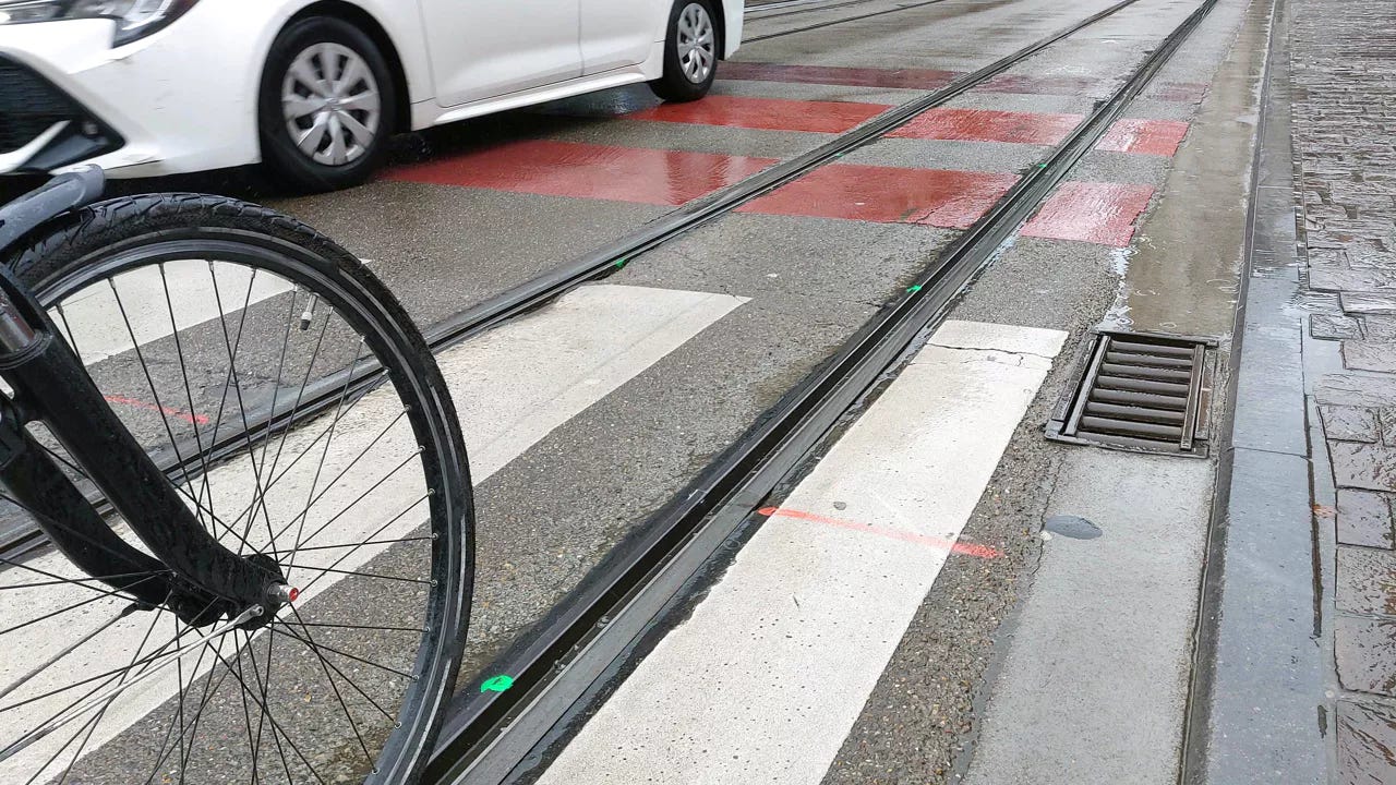 Primo piano di una ruota di bicicletta vicina alla rotaia di un tram, a Gent.