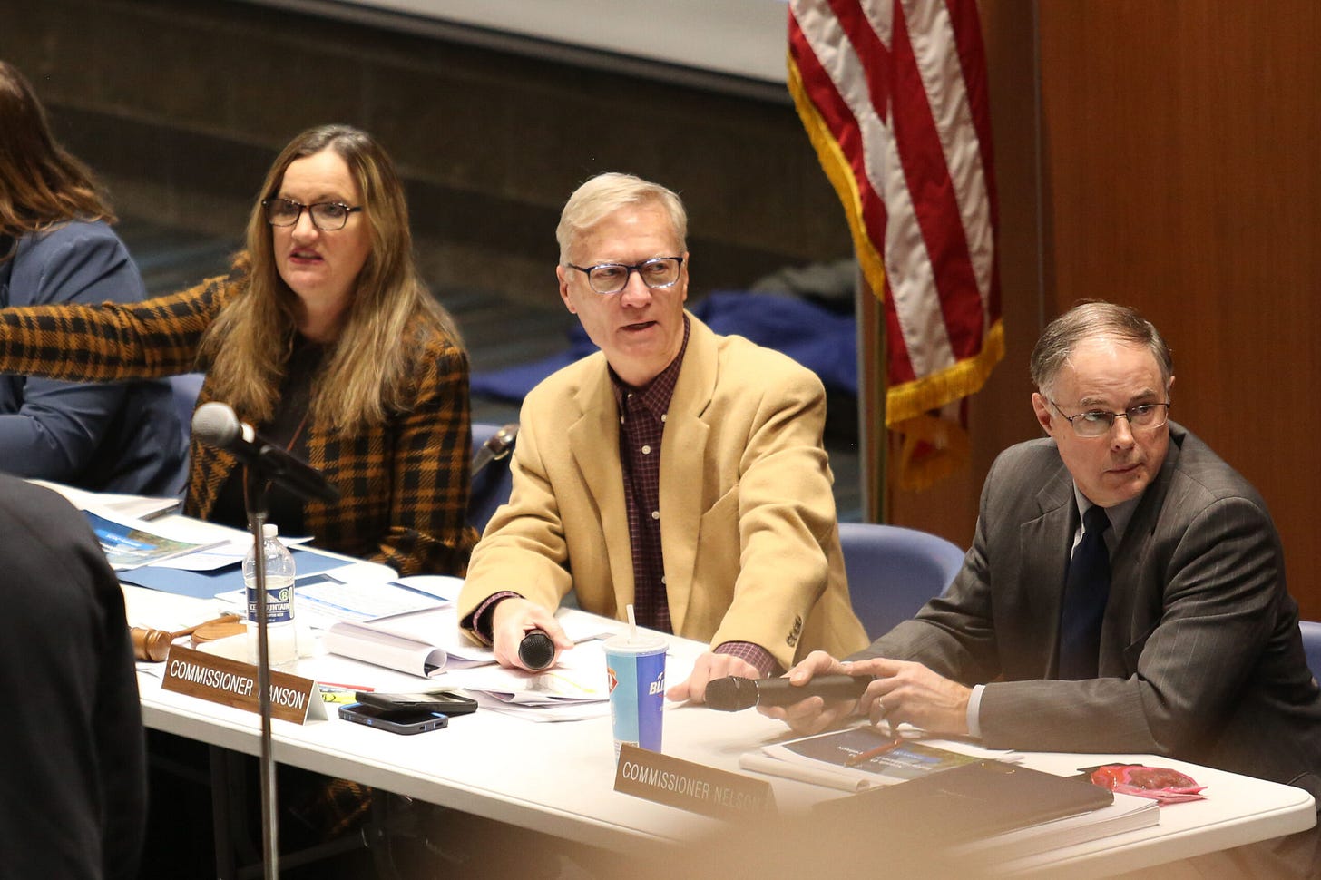 (From left to right) Public Utilities Commissioners Kristie Fiegen, Gary Hanson and Chris Nelson wait for a public hearing meeting to begin in Sioux Falls on Jan. 15, 2025. (Makenzie Huber/South Dakota Searchlight)