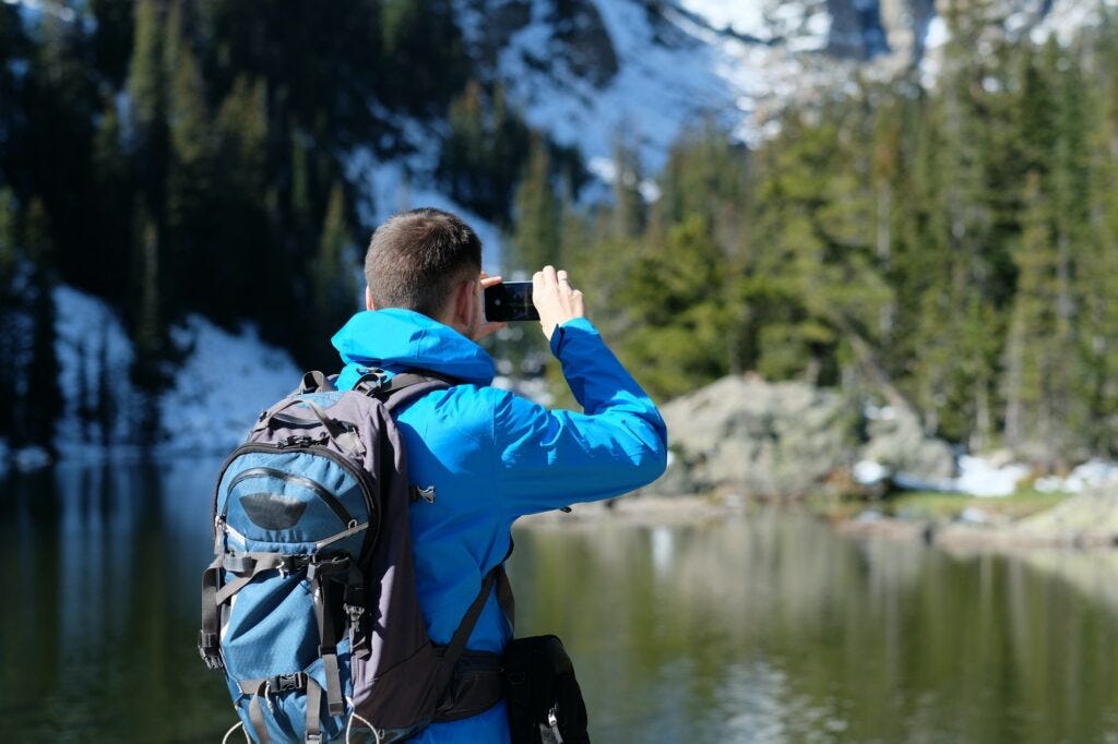 Backpacker taking photo with smartphone