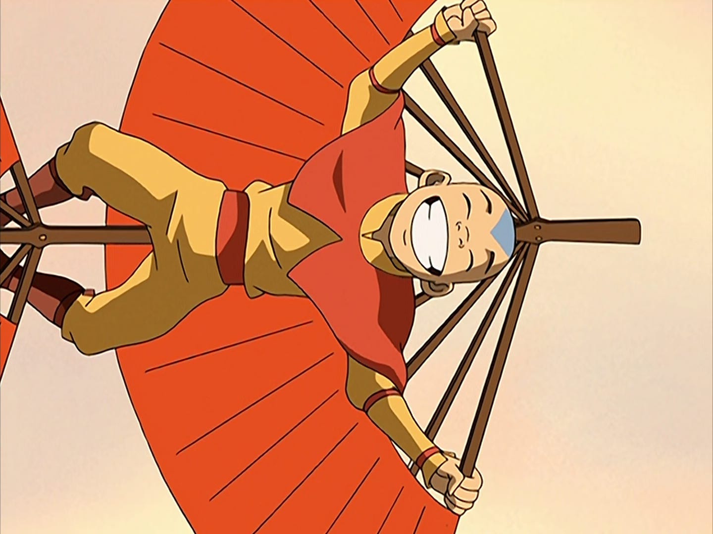 Aang flies on his glider with his eyes closed and a big smile on his face.