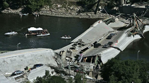 Vehicles on a collapsed bridge over water.