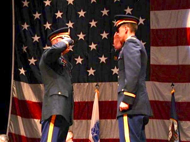 A group of men saluting in front of a flag

Description automatically generated