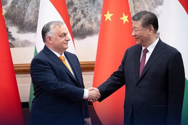 Viktor Orban and Xi Jinping shake hands while facing each other in front of flags. 