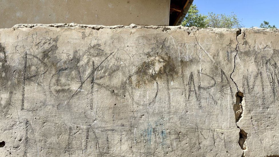 Faded Boko Haram graffiti on a wall in Damasak