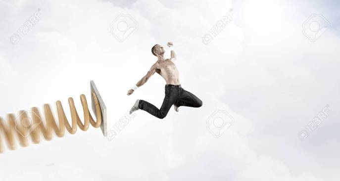 Young Man Jumping On Spring And Flying In Air Stock Photo, Picture And  Royalty Free Image. Image 57017482.