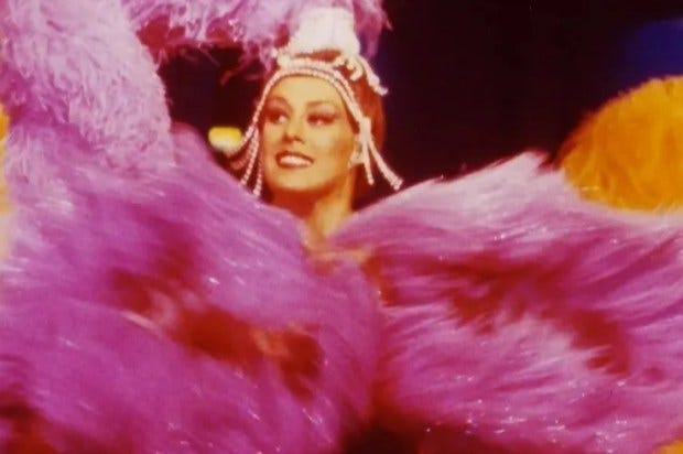 Photo of Janet Pharaoh, artistic director of the Moulin Rouge, in a feathered costume.