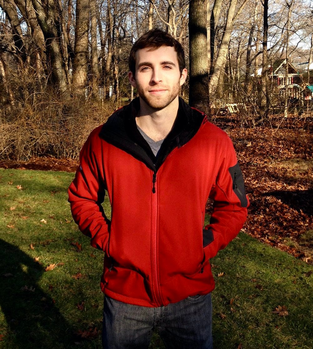 picture of the author wearing a red jacket while standing outside on a lawn