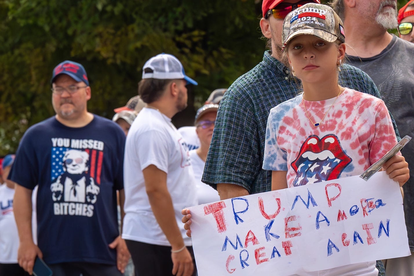 A child holding a sign

Description automatically generated