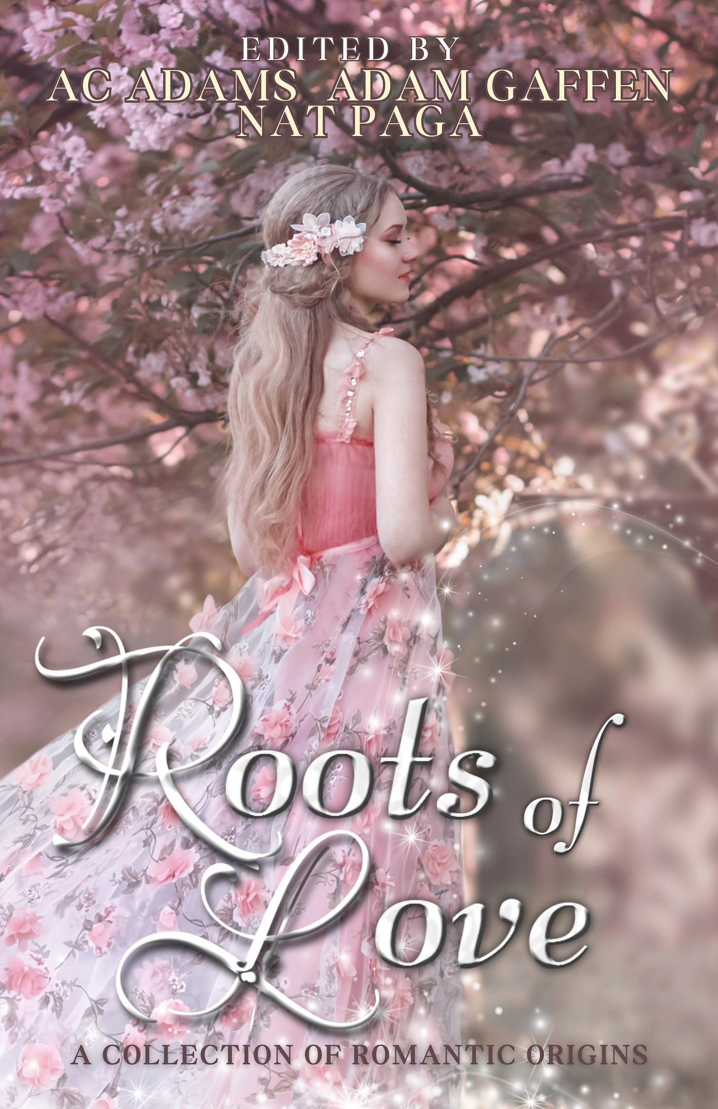 Text: Edited by AC Adams Adam Gaffen Nat Paga. The Roots of Love, A Collection of Romantic Origins. Book Cover Image: A blonde woman with fair skin in pink on a backdrop of a pink flowering tree.