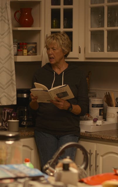Annette Benning as Diana Nyad holds a book of poems in her kitchen and, in another photo, her bathroom