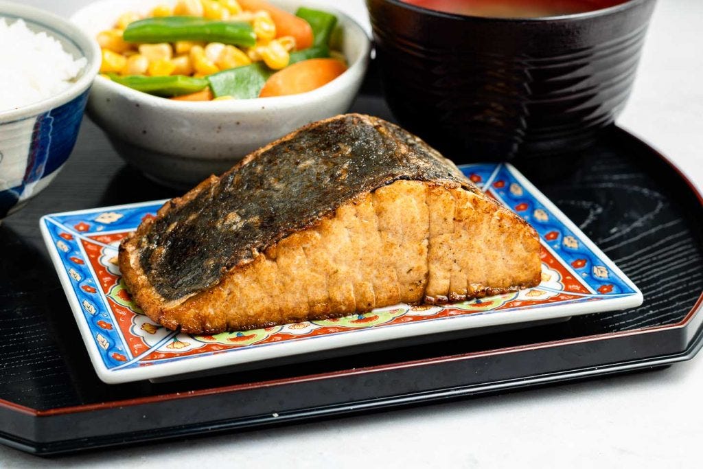 vegan tofu fish on a rectangle plate on a black tray