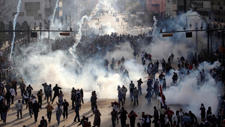 Protesters flee from tear gas fire during clashes in Cairo.