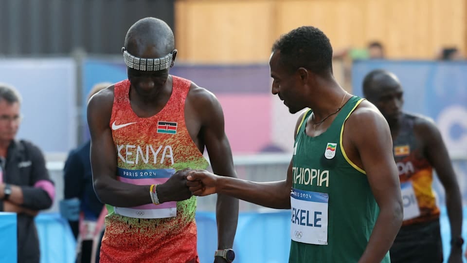 Eliud Kipchoge of Kenya bumps fists with Kenenisa Bekele of Ethiopia before the race.