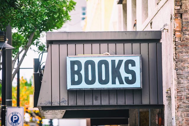 A bookstore's awning that has a sign affixed to it. The sign says "books."