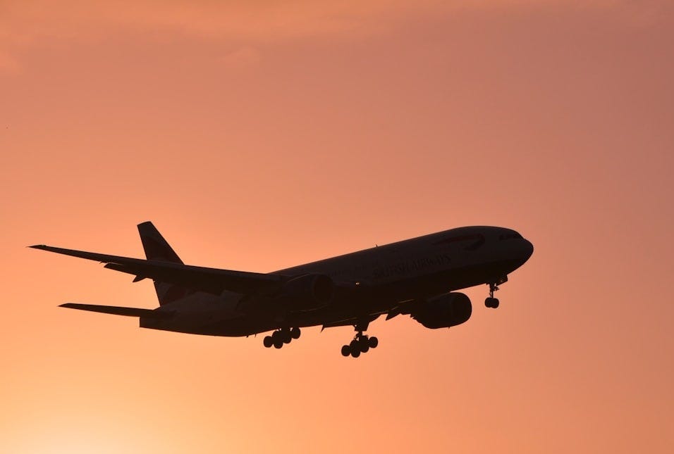 a large jetliner flying through a sunset sky