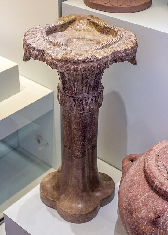 Porphyry stone pedestal oil lamp with decorative carving from the Minoan site of Knossos