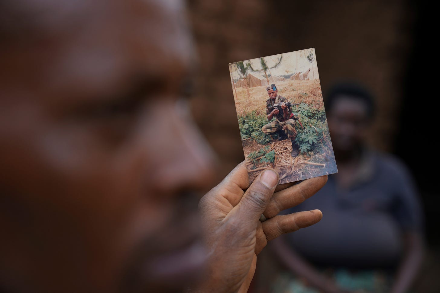 Patrick Hakizimana, a Hutu peasant who was jailed from 1996 to 2007 for his alleged role in the genocide as an army corporal, shows a photo during his time as a soldier in Gahanga the outskirts of Kigali, Rwanda.