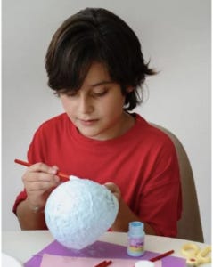 child making papier-mache