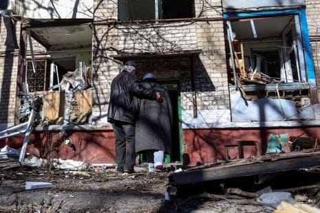A couple enter a residential building damaged by a Russian missile strike in Kramatorsk.