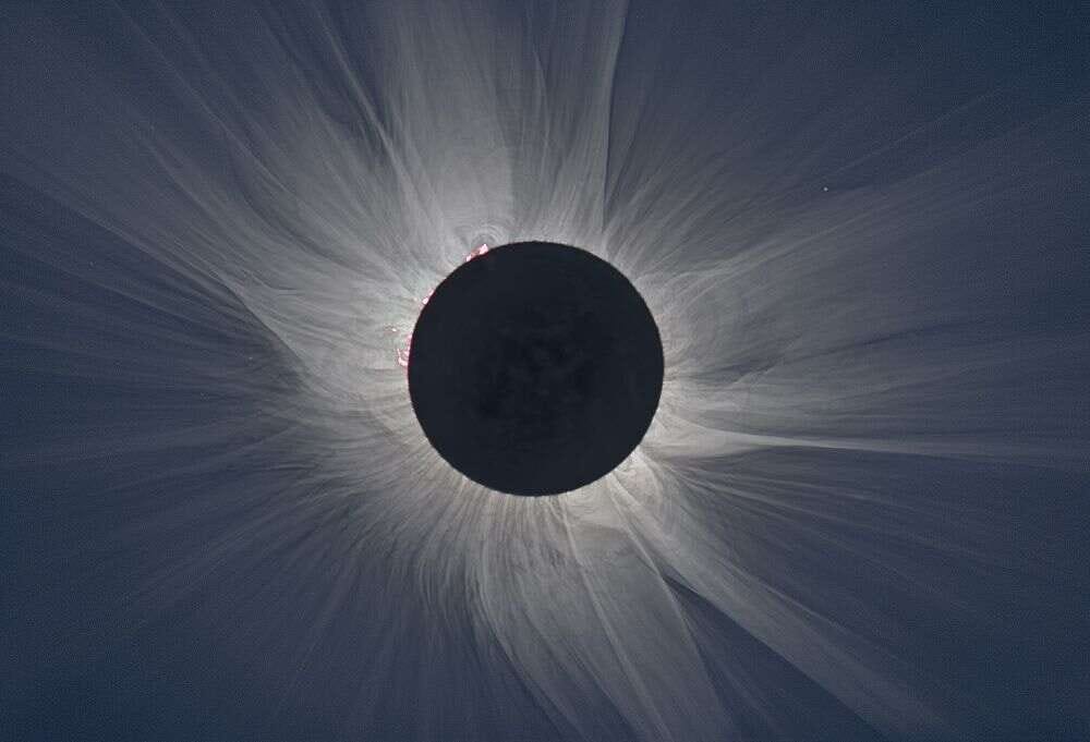 totality with Sun's outer atmosphere glowing and wisping around obscured Sun