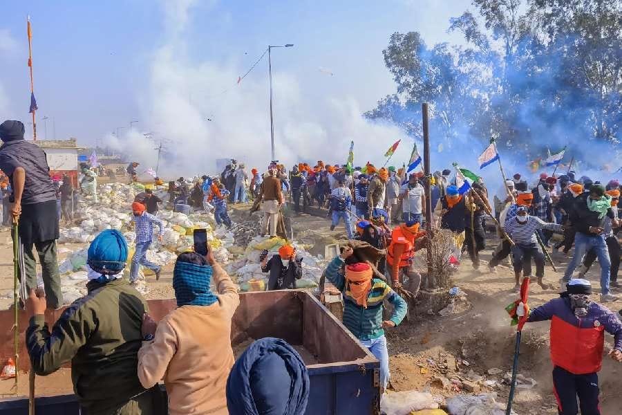 Farmers look for cover after police fired tear gas at them during their 'Delhi Chalo' march, near the Punjab-Haryana Shambhu border, in Patiala district.