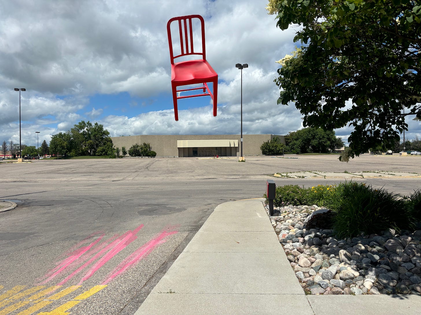 chair floating above shopping mall with clouds above and large empty parking lot -- plus drawn pink lines