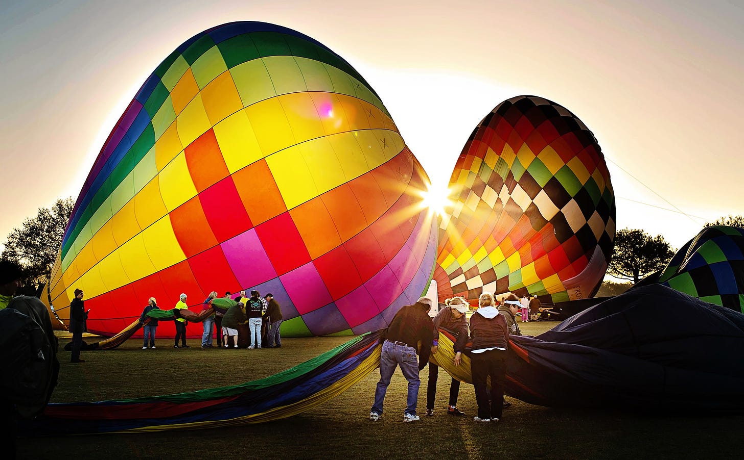 Multi-colored hot air balloons preparing to launch