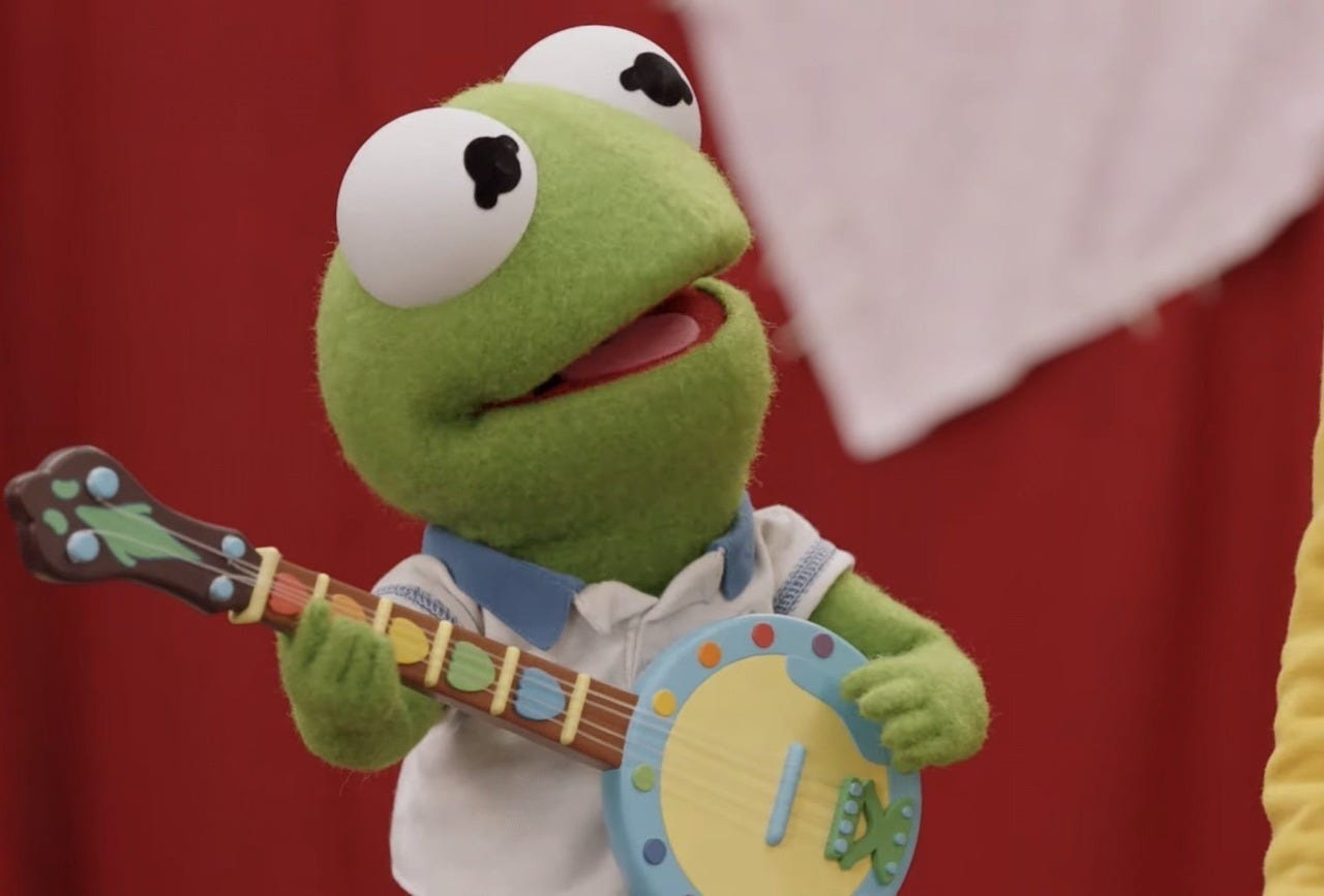 small kermit the frog playing a banjo