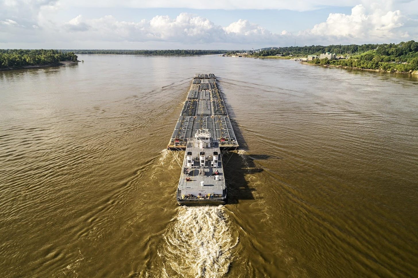 A tug boat and barges on the Mississippi River. Image from Unsplash.