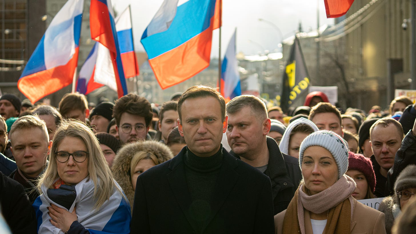Alexey Navalny marching for freedom in Russia, with Russian flags in the background