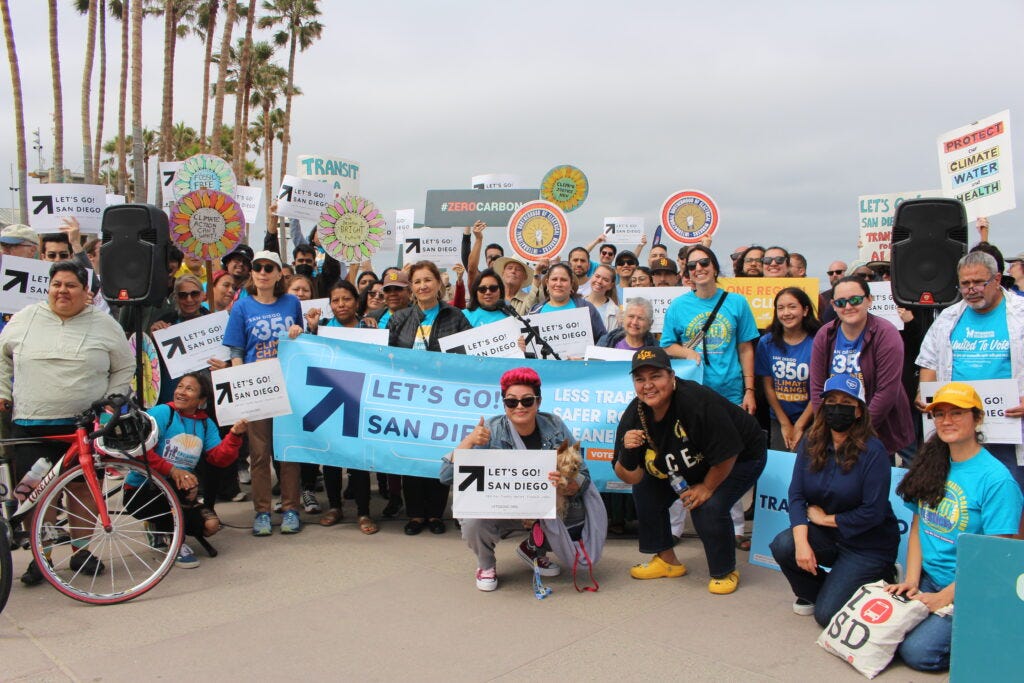 Group photo of people holding "Let's go! San Diego signs