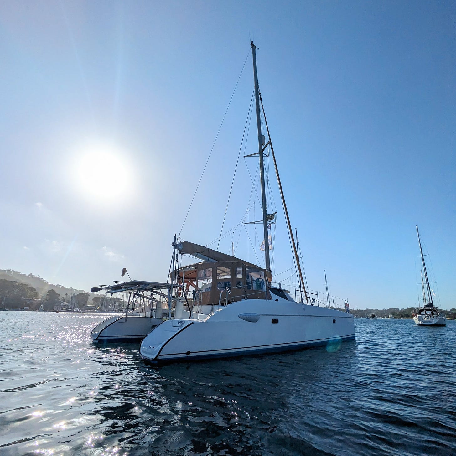 a 40-foot catamaran in a harbor full of boats, moored to a buoy