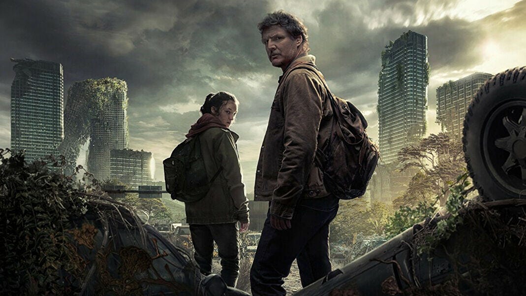 Promo picture of Bella Ramsey and Pedro Pascal standing among ruins.
