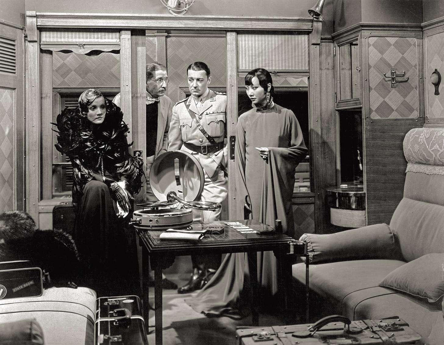 Marlene Dietrich, Clive Brook, and AMW stand in a train car in a scene from Shanghai Express (1932)