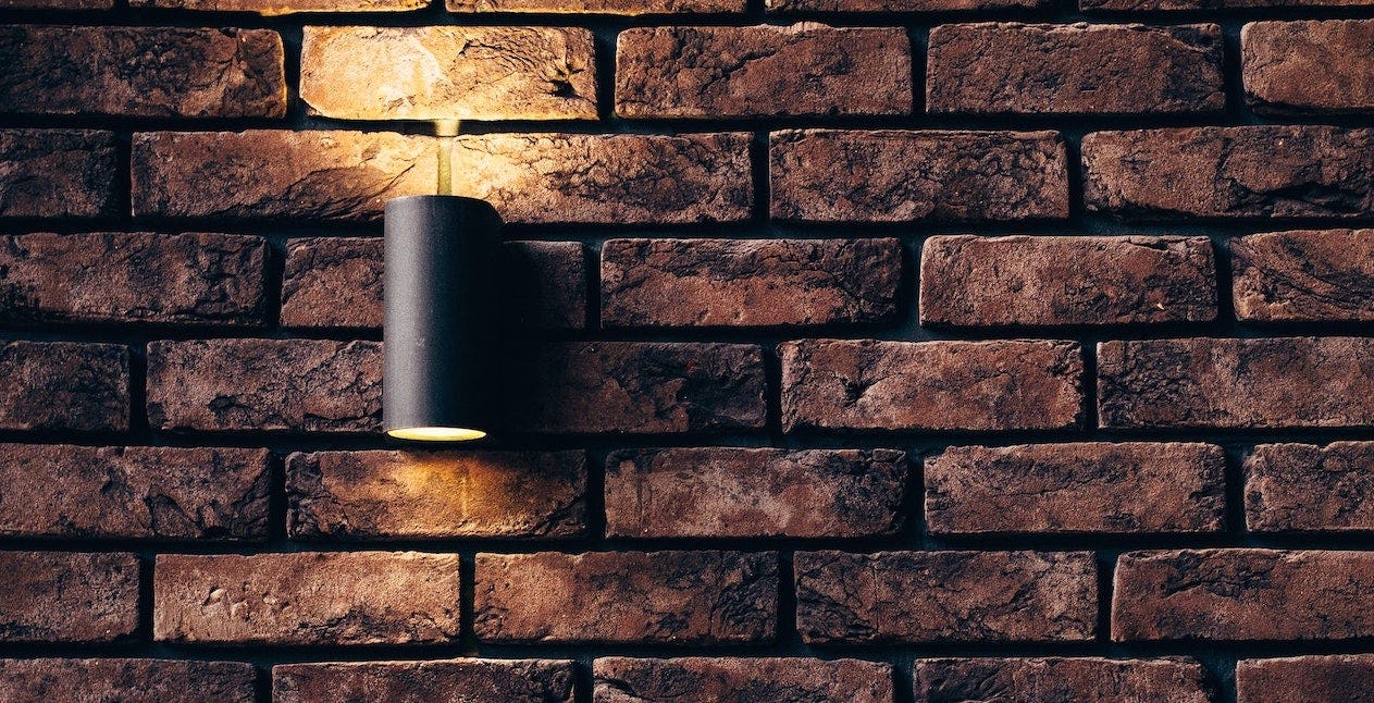 A bright sconce on a brick wall