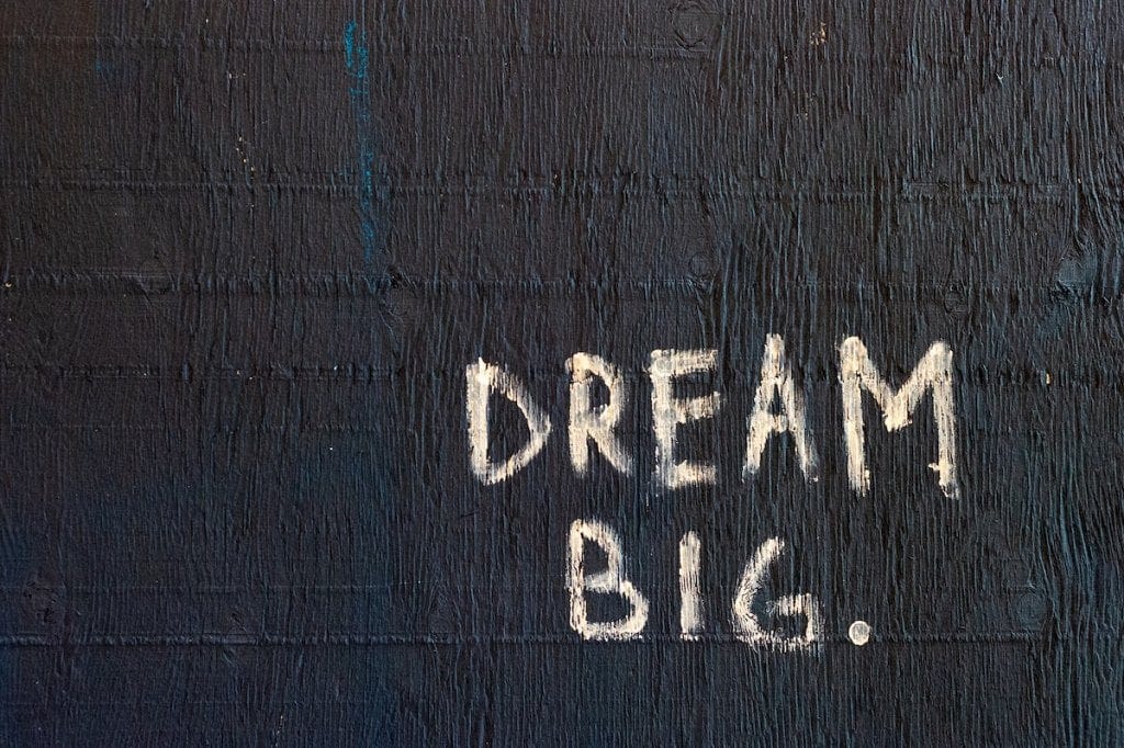 Graffiti on a wall that reads: "Dream big."