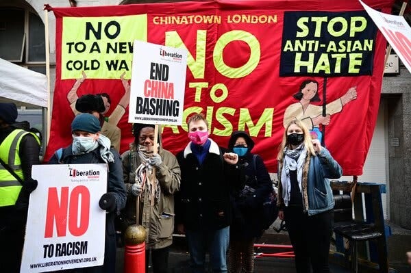 Protesters with signs reading “No to Racism” and “End China Bashing.”